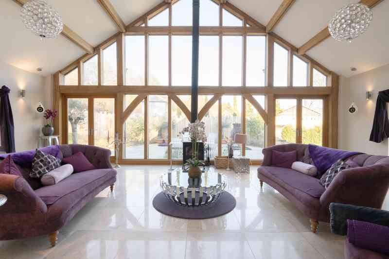 The living room features high vaulted ceilings and a garden view